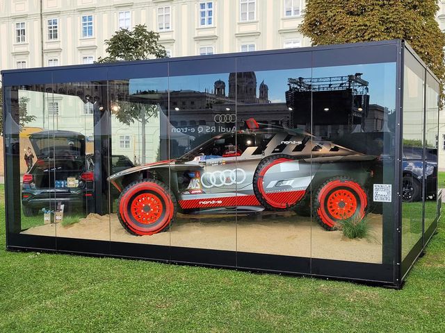 Ein Promotioncontainer mit Glasfront und Auto von Audi im Inneren